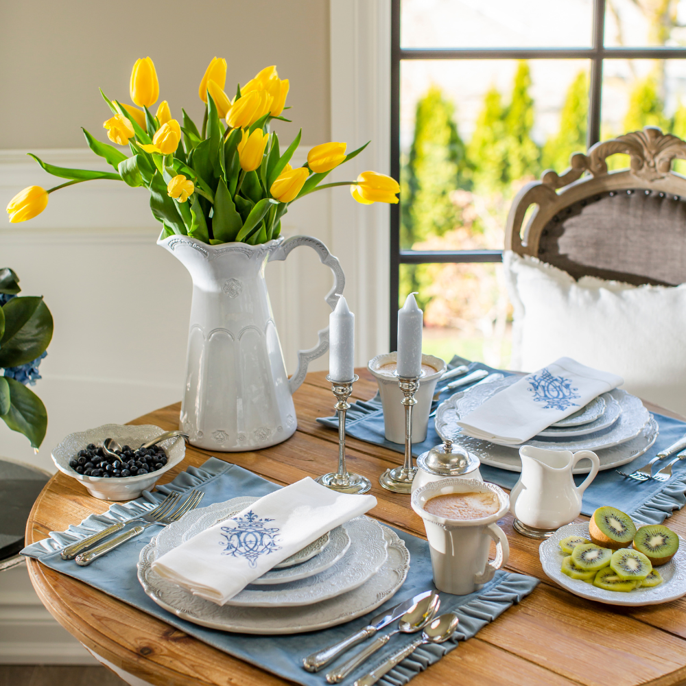 Merletto Antique Scalloped Pitcher with yellow flowers set on table with blue accents
