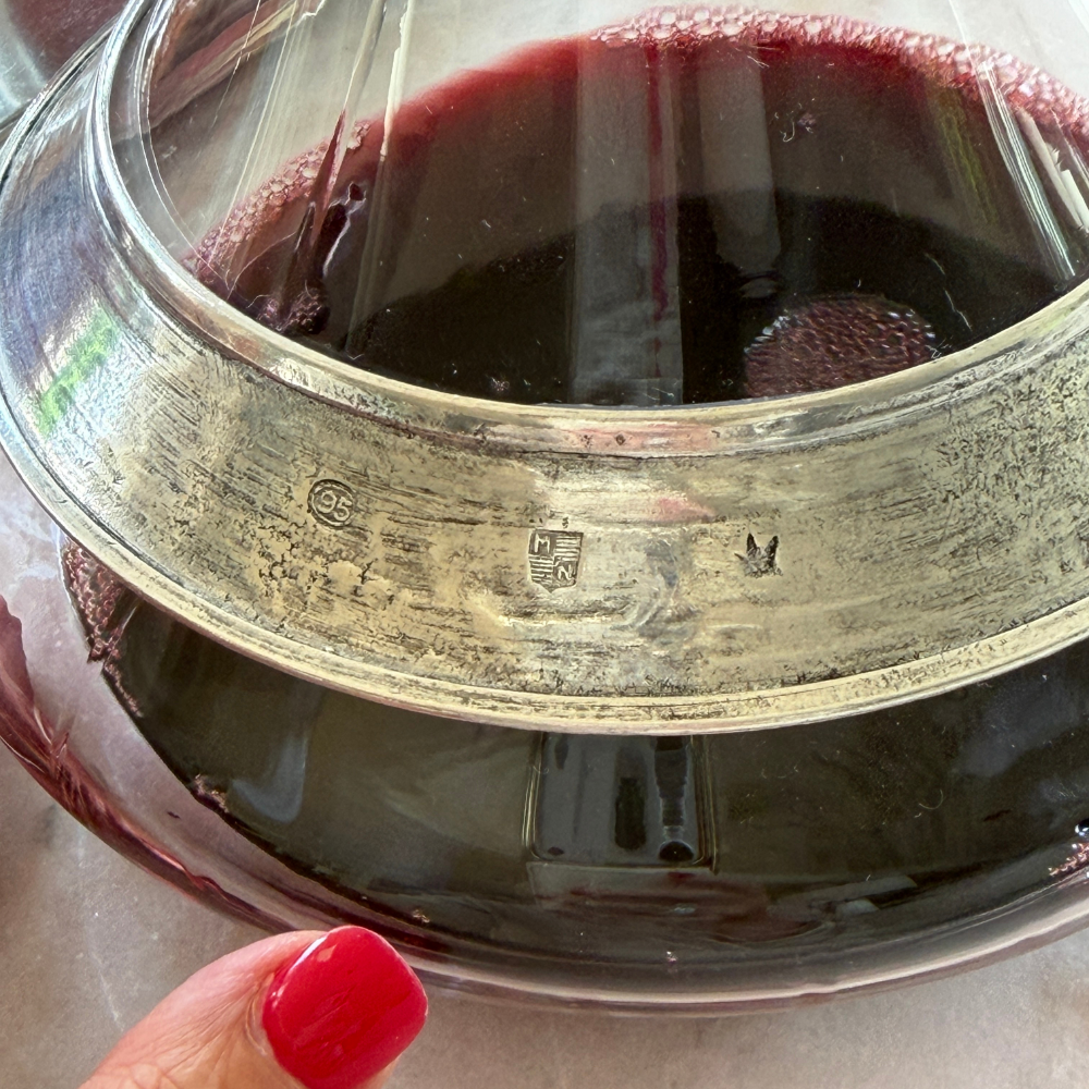 Close-up of the handcrafted Italian pewter band on the Arte Italica Taverna Wine Decanter, showing artisan hallmark stamps, filled with red wine
