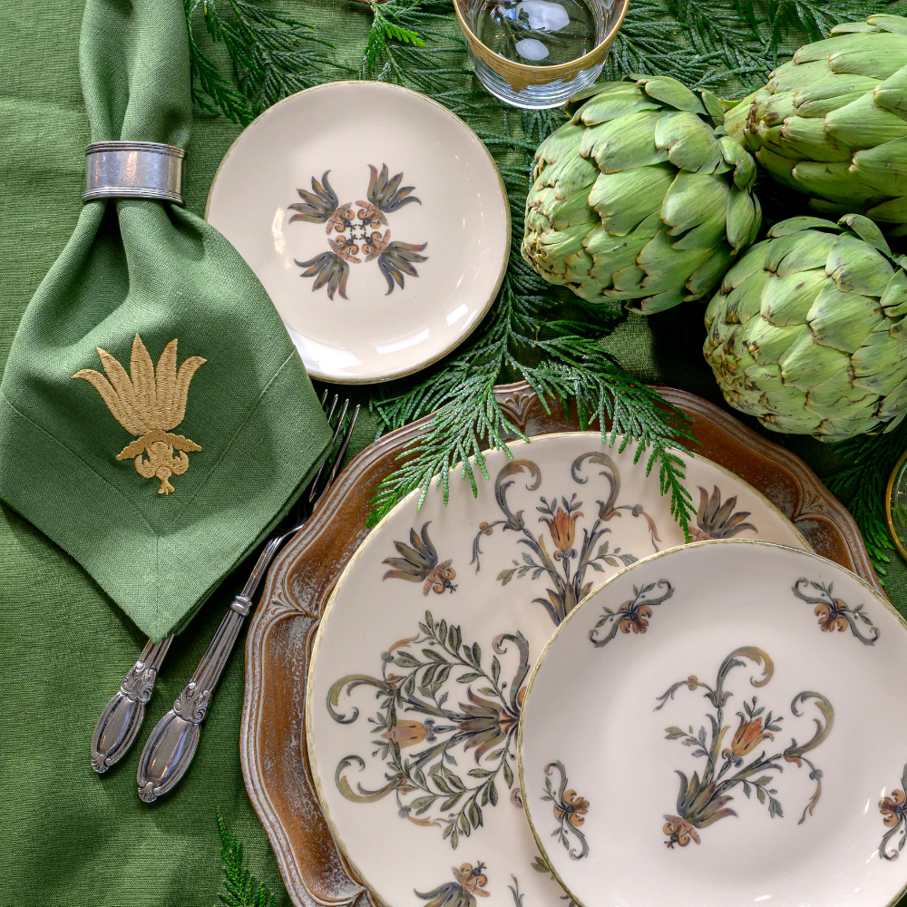 Villa Italian Dinnerware table setting with artichokes, and an Evergreen Villa Floret dinner napkin.