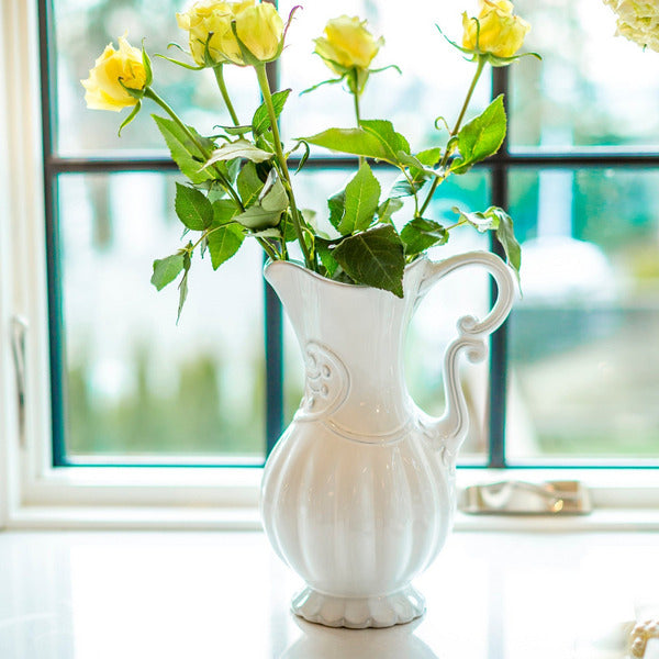 Arte Italica Bella Bianca Italian stoneware pitcher white glaze used as a vase with roses on a counter