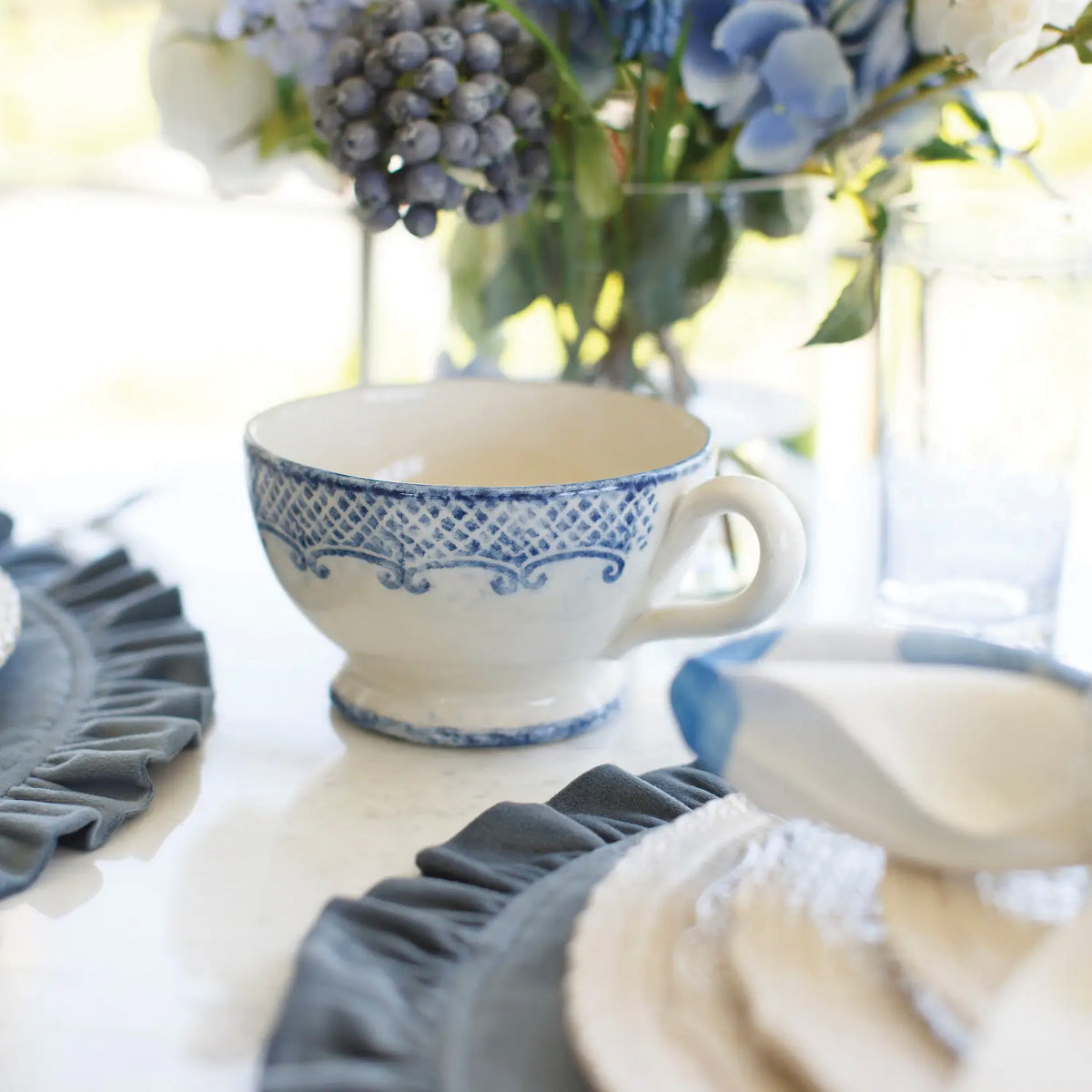Arte Italica Burano grande cup blue ceramic Italian hand painted dinnerware, ceramic coffee and tea cup at a table placesetting