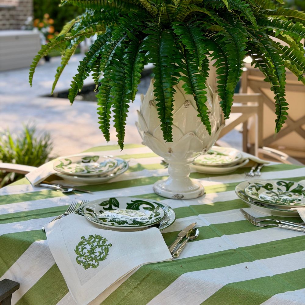 Outdoor table setting with Al Fresco Plates and green and white lines. 