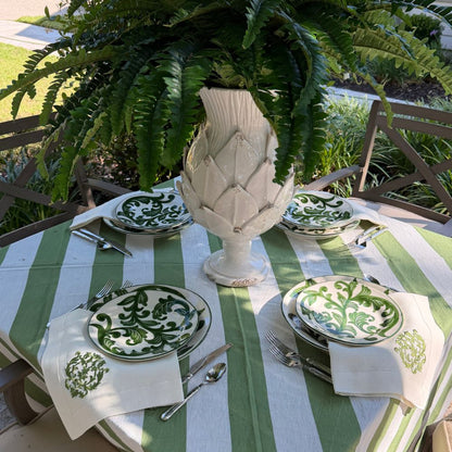 Outdoor table setting with Al Fresco plates, green and white linens, and a Scavo vase. 