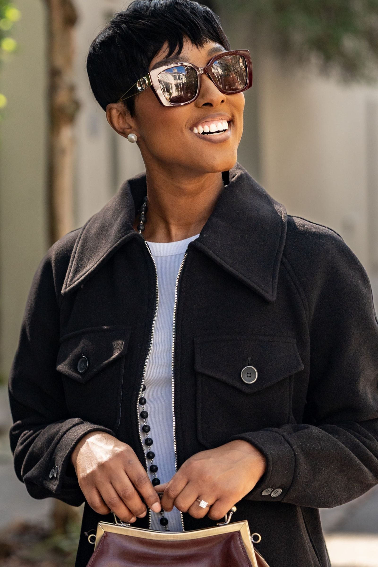 Woman wearing a black Alex Wool Cashmere Viscose blend coat and wearing sunglasses, holding a brown leather bag.