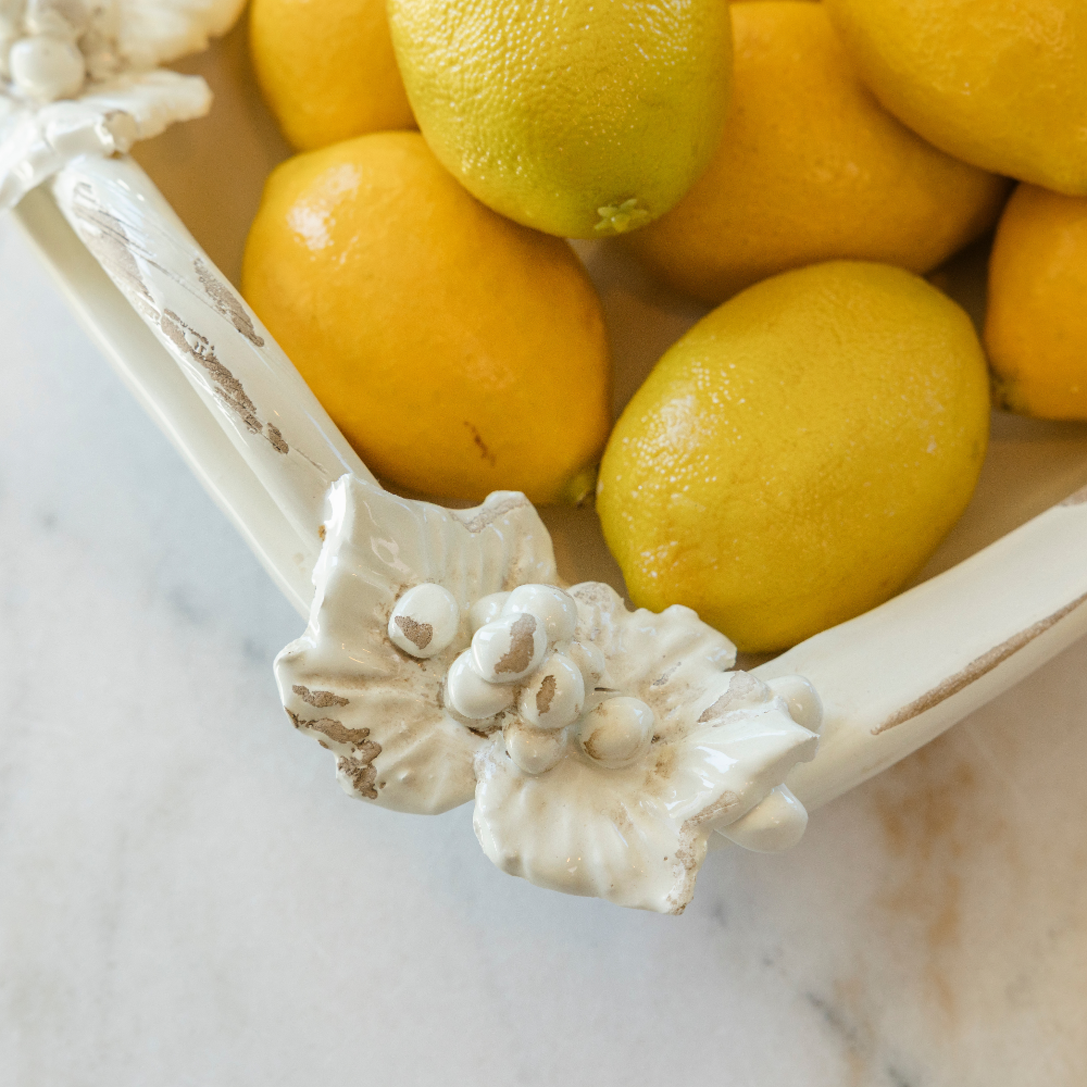 Detail of the corner of the ceramic Antico Toscana rectangular dish filled with lemons showing the leaves and vines