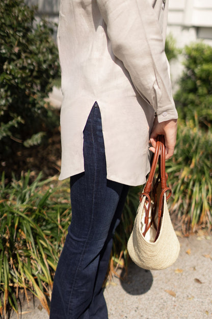 Detailed shot of the side of the Christina linen top with model posing outside. --Arte Italica and Crown Linen Designs