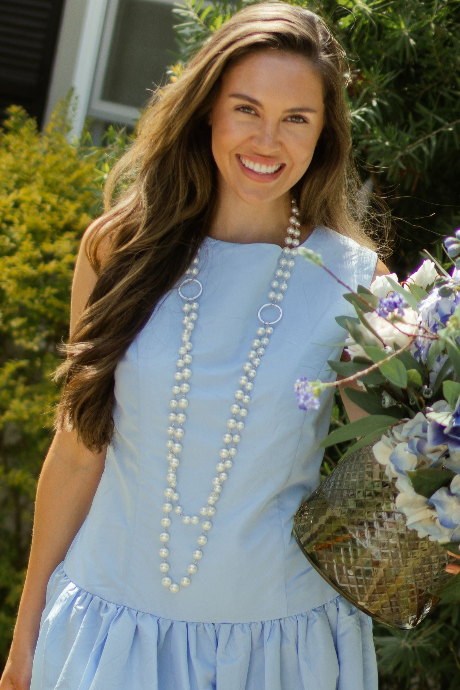 Woman posing in light blue taffeta dress wearing silver double pearl strand necklace. --Arte Italica and Crown Linen Designs