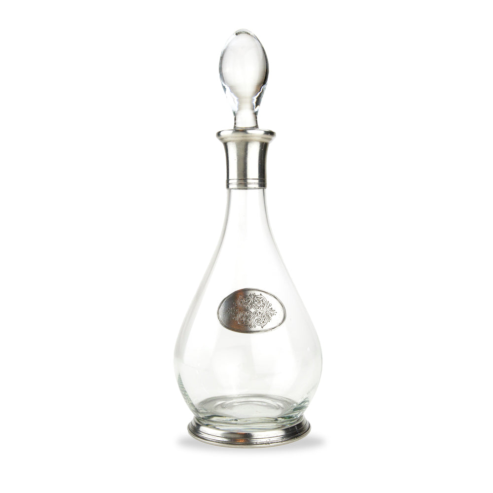 A glass decanter with a pewter base and neck and a tear drop shape decoration, including a glass stopper.