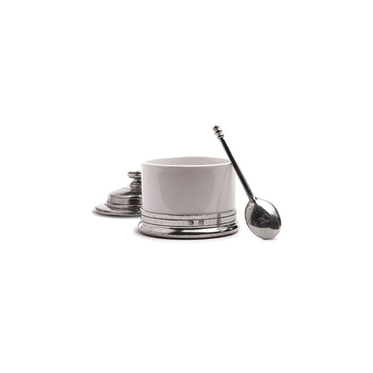 Tuscan covered ceramic bowl with pewter, base and spoon on a white background