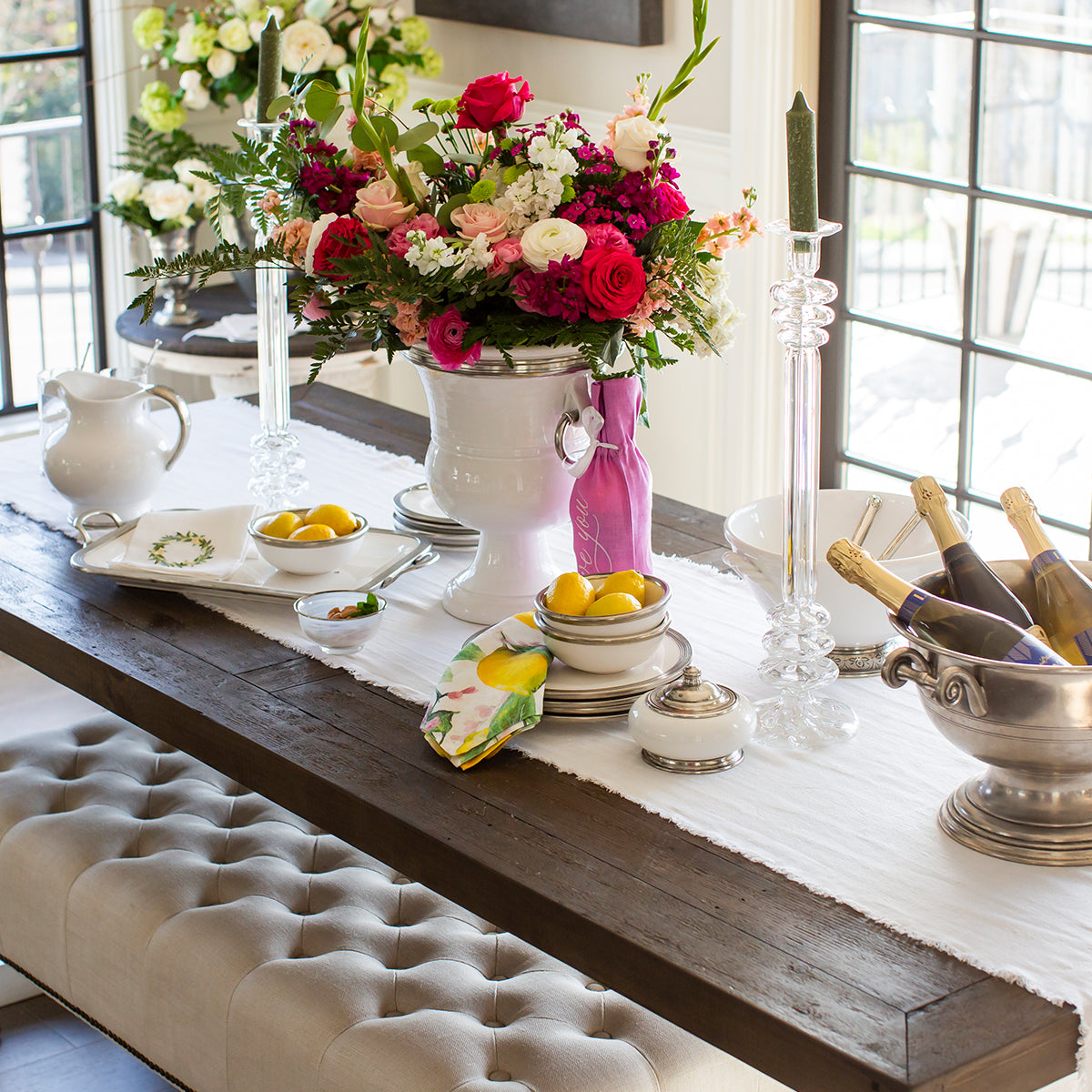 Tuscan ceramic and pewter dishes on a table with lemons, flowers and Champaign