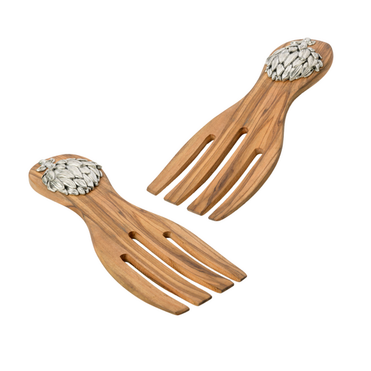 Wooden salad servers with decorative pewter artichoke emblems on the handles on a white background