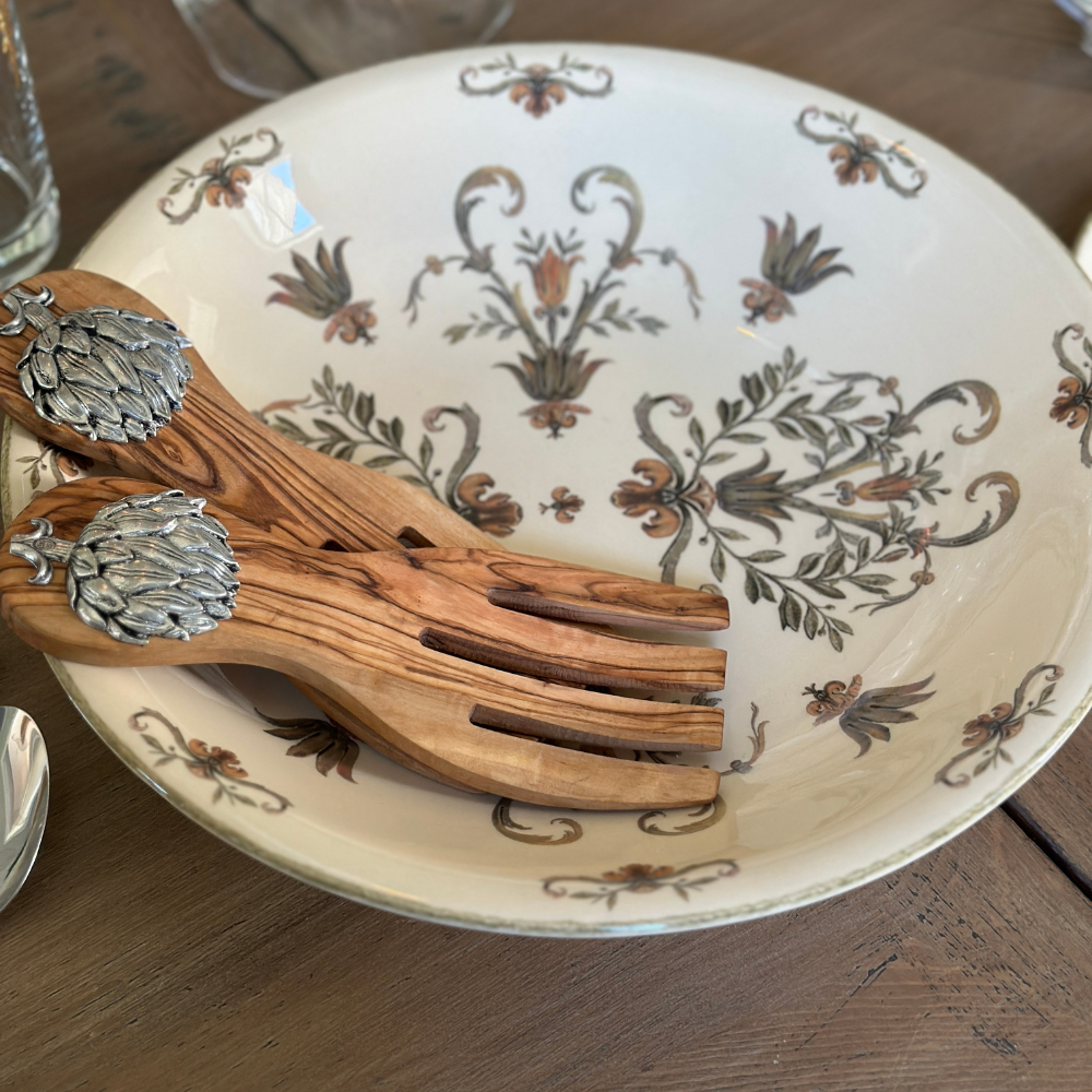 Decorative Villa plate with Italian floral patterns and Artichoke wooden spoons on a wooden surface