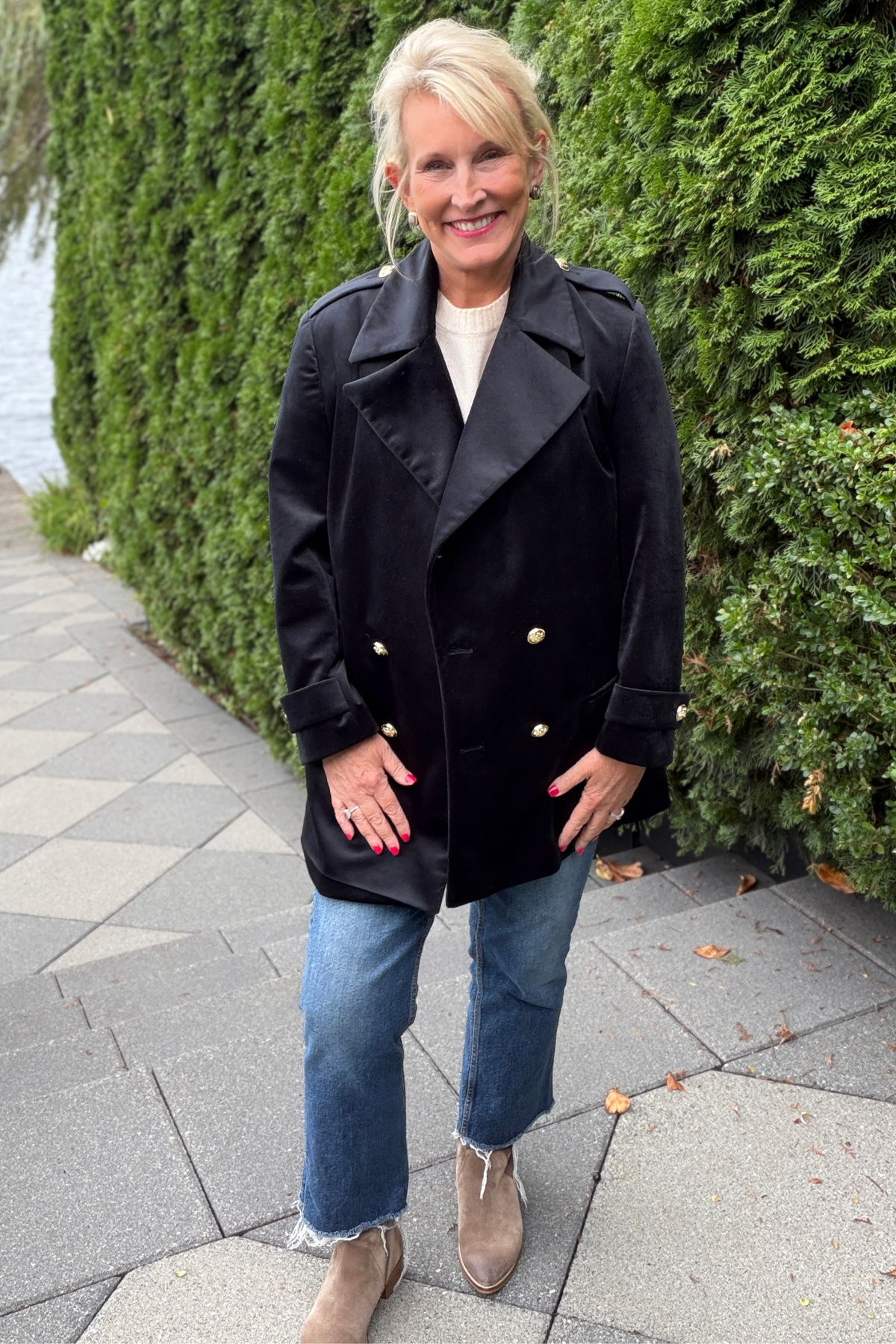 Avery Luxury Velvet Blazer in black with gold buttons, styled with a white top, cropped jeans, and tan ankle boots on an outdoor stone walkway