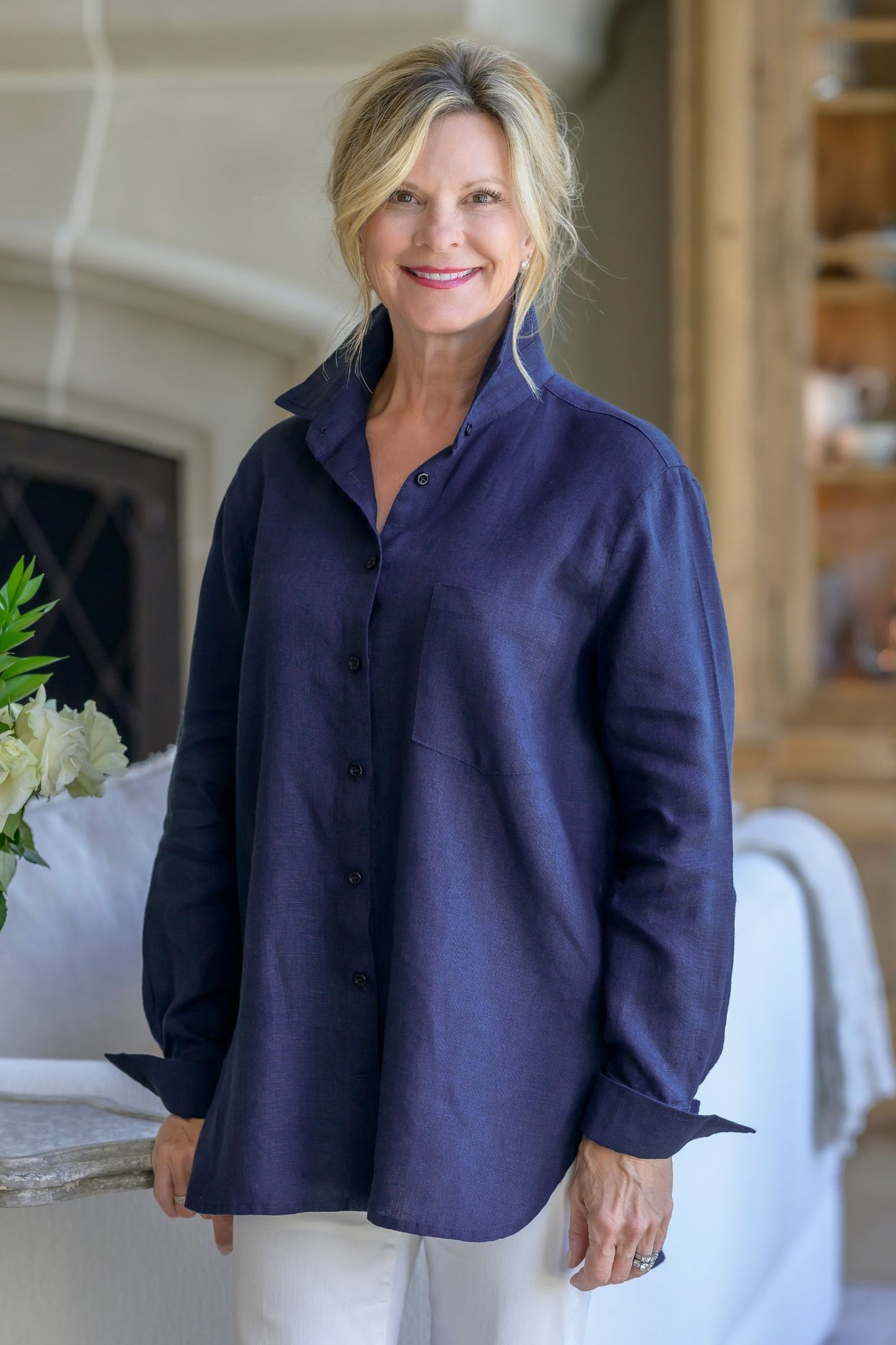 Woman wearing a navy blue Belmont Button Up Blouse in a home setting