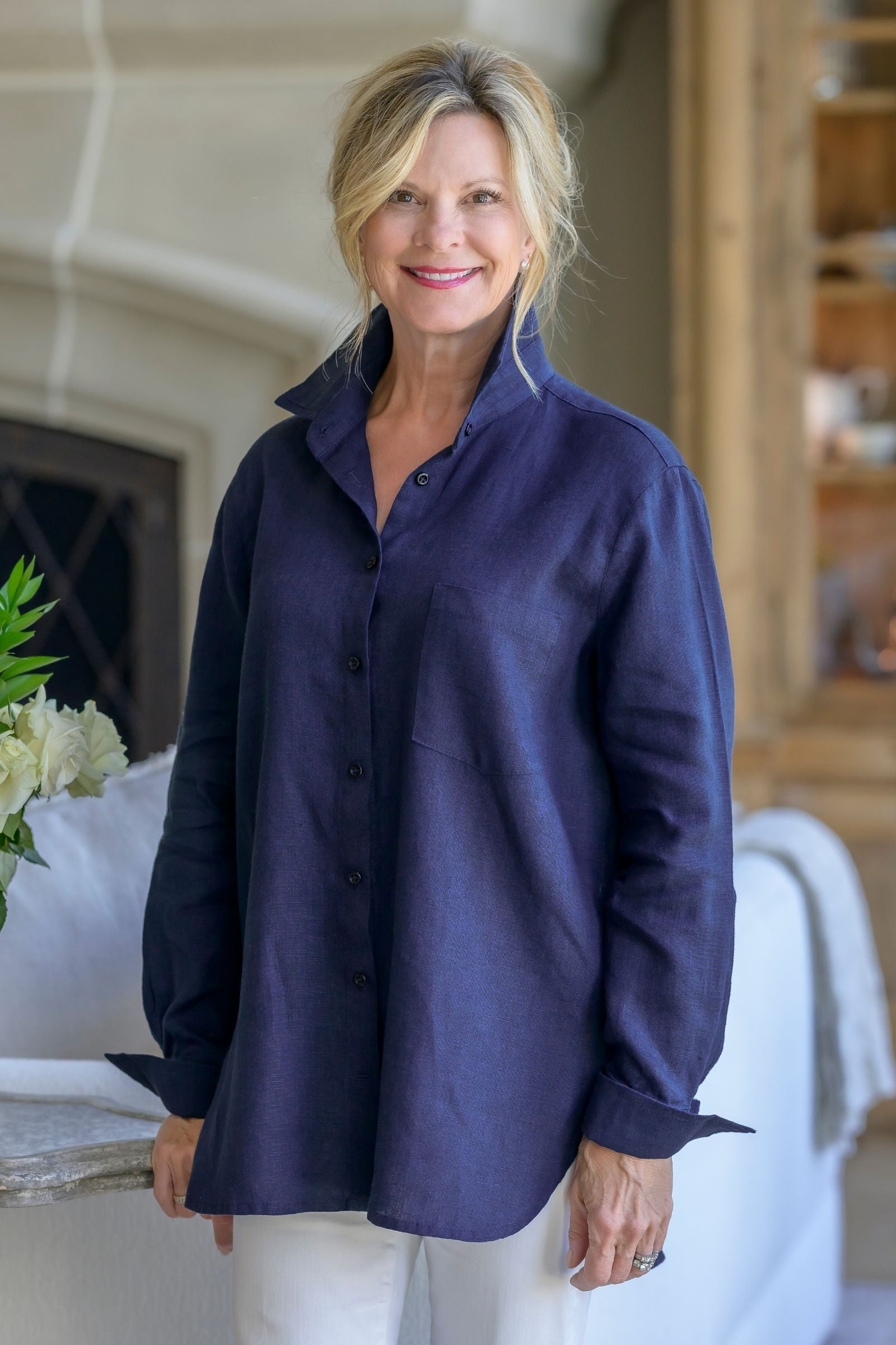 Woman wearing a navy blue Belmont Button Up Blouse in a home setting