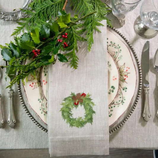 Juniper Wreath Linen Towel on Christmas plates on top of heathered tablecloth