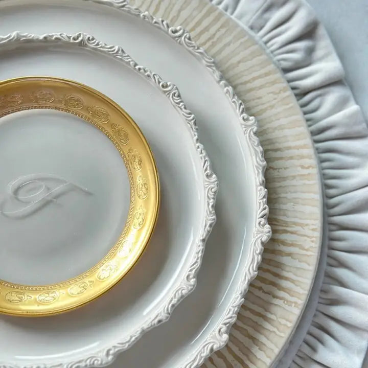 Close up of a stack of plates with Cream Striped Charger and Imperial on a Cream Placemat
