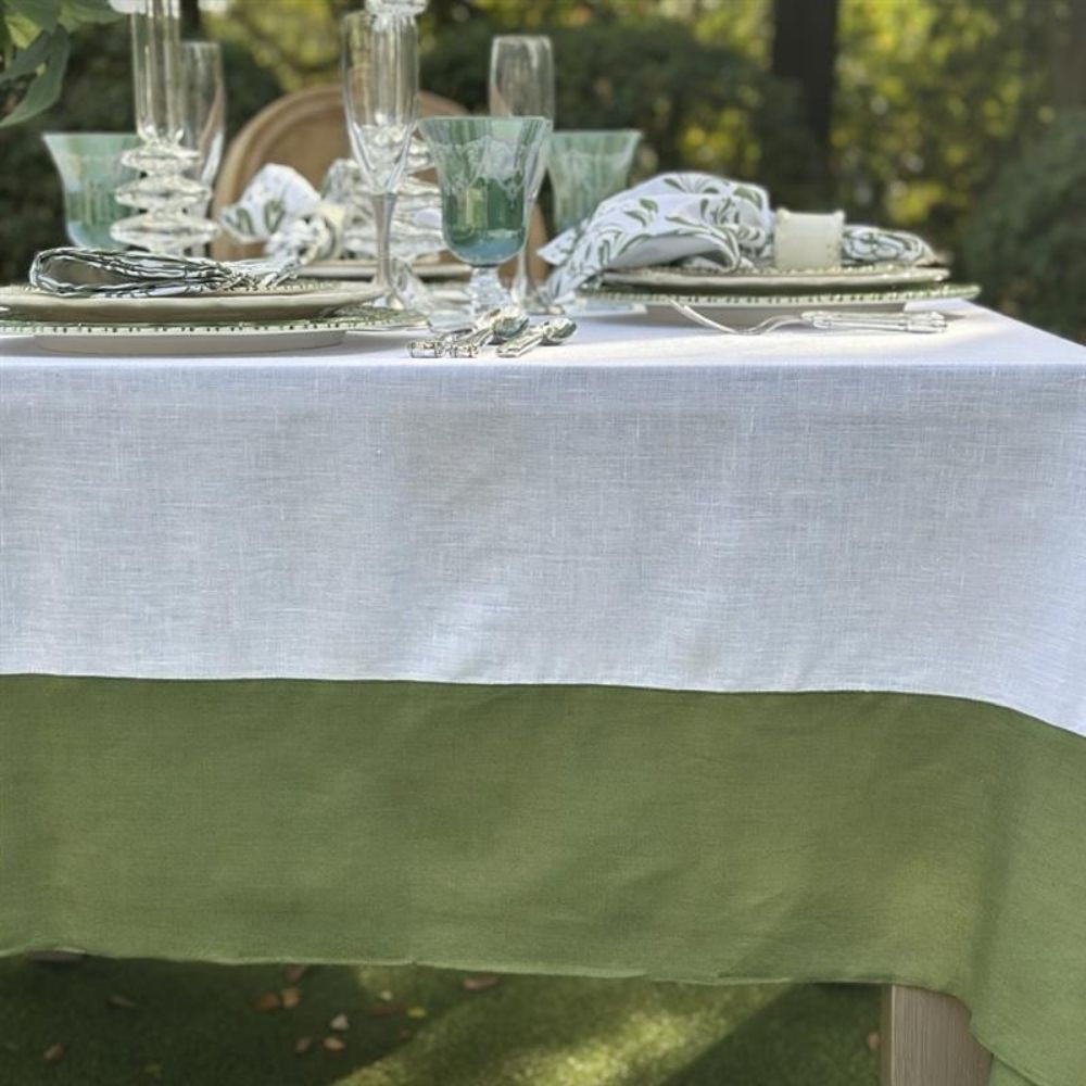 Table setting with green and white linen tablecloth outdoors