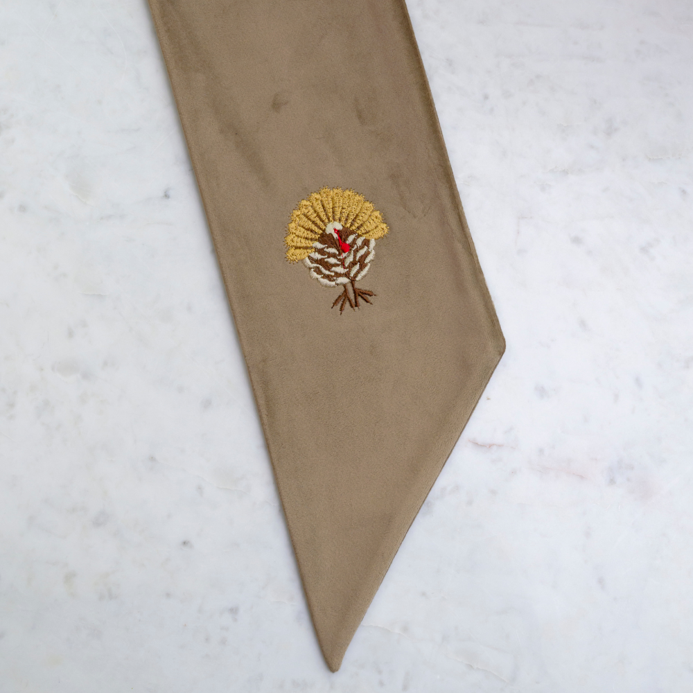 Mocha Velvet Bow Sash with embroidered Turkey design on a light gray background