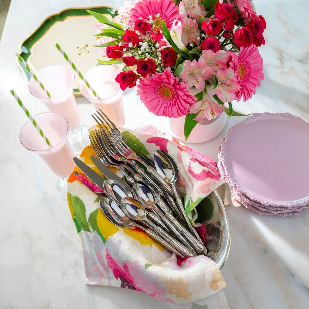 Crown Linen Portofino Summer Garden Large Linen Napkin styled in a basket with flatware