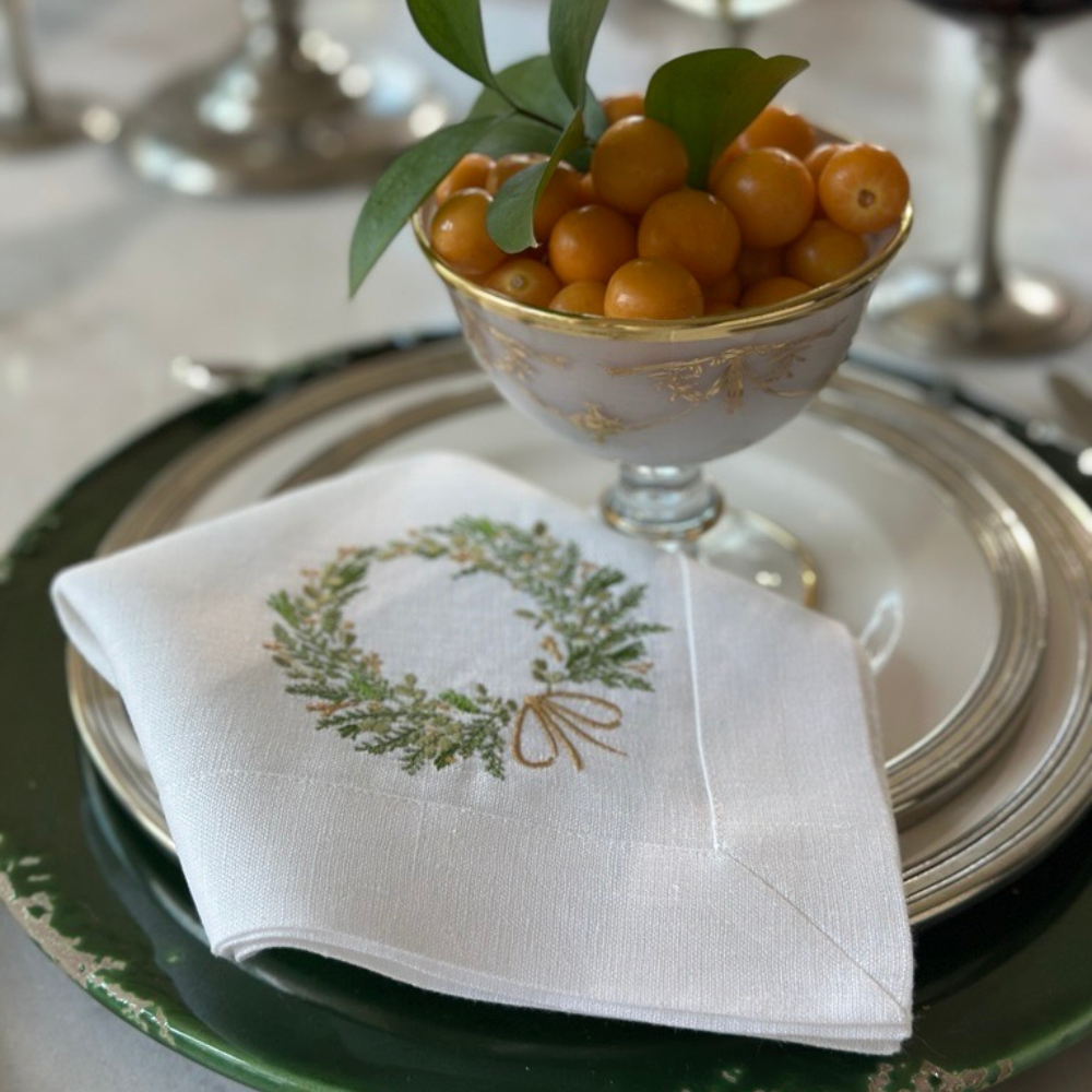 Tuscan Dinner table setting with a white linen napkin featuring a Farmers Market Green and gold wreath design.