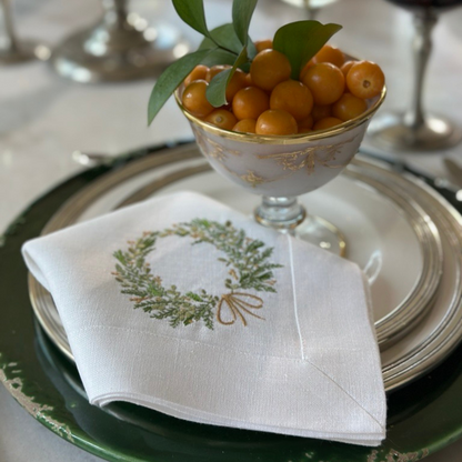 Tuscan Dinner table setting with a white linen napkin featuring a Farmers Market Green and gold wreath design.