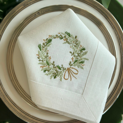 Napkin with embroidered wreath design on a plate
