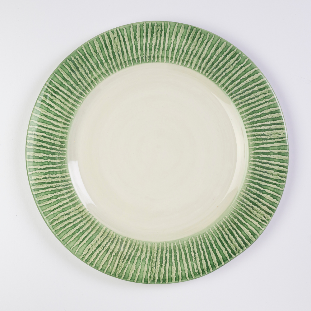 A round ceramic charger with a hand-painted striped pattern in green and cream colors.