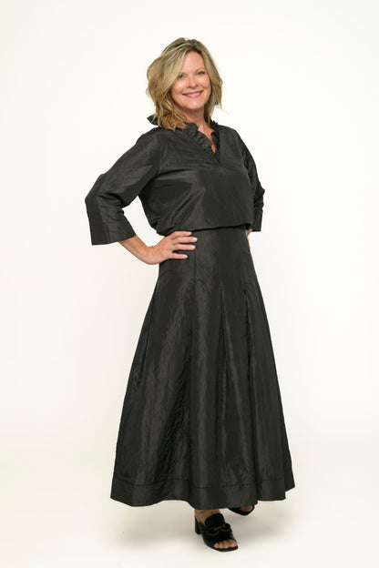 Woman wearing a black taffeta outfit on a white background