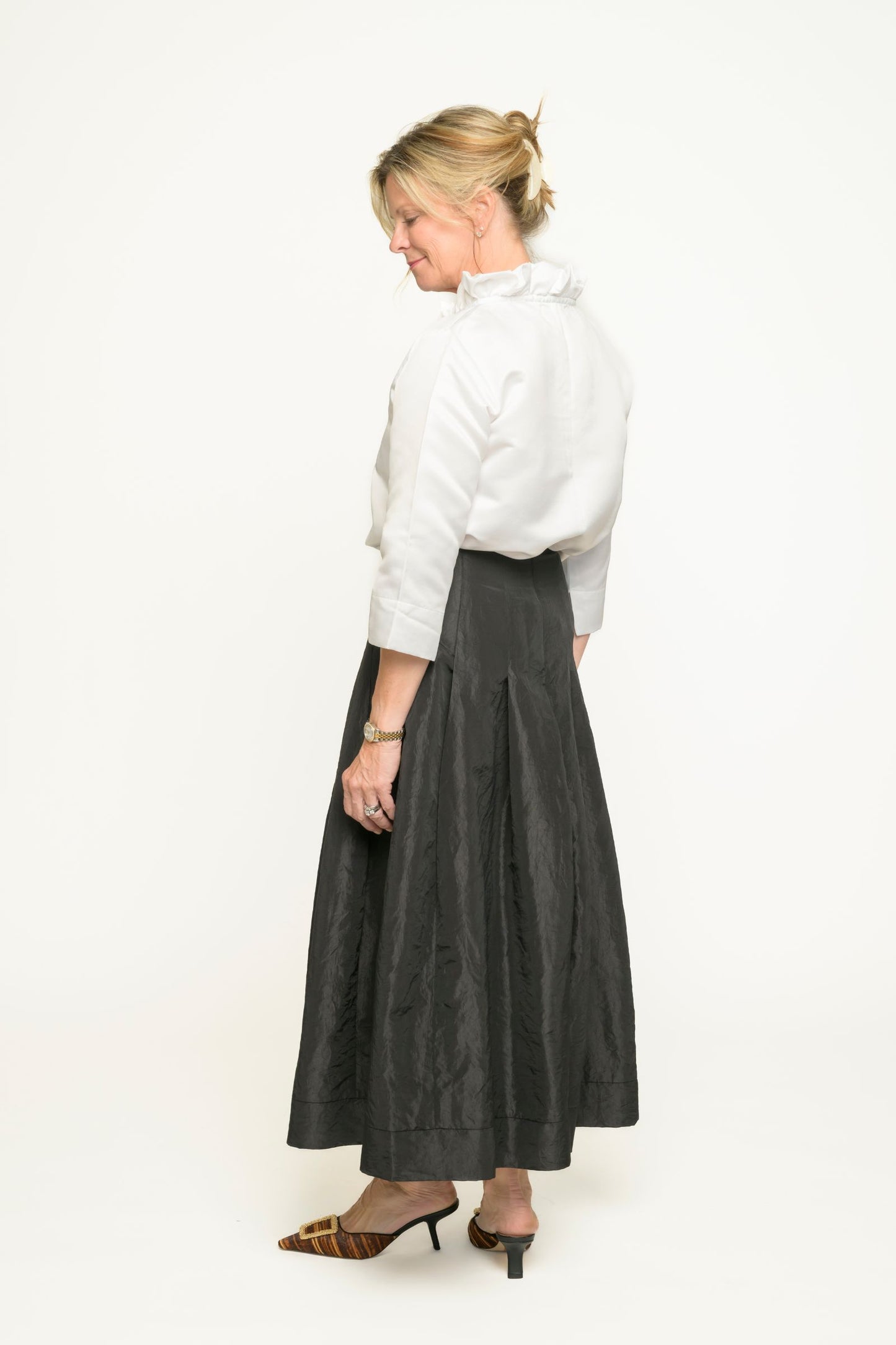 Woman wearing a white blouse and black taffeta skirt on a white background