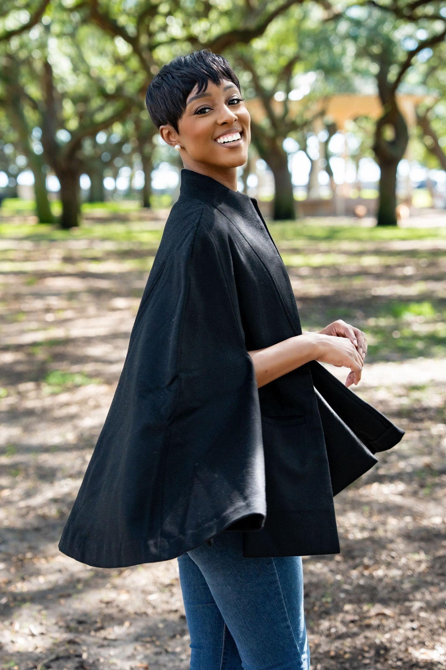 Woman wearing a black Marilyn Cape in a park setting