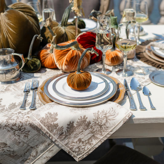 A fall table set with Velvet Hot Skwash pumpkins with Tuscan dinnerware and Montefalco cotton toile Napkin and Tablecloth in Latte color