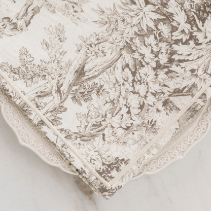 A latte brown montefalco toile cotton napkin on a Firenze plate on a marble table