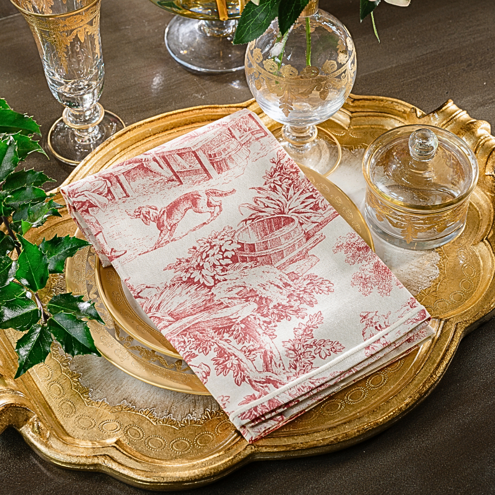 A Montefalco Toile in Red folded on a Florentino Red Tray with Vetro Gold plates and covered dish