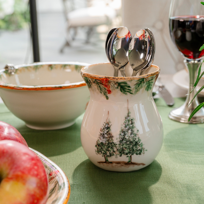 A Natale Italian ceramic small vase on a table with evergreen linen holding spoons