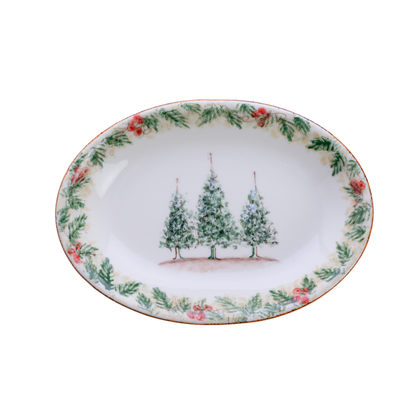 A small oval Natale hand painted ceramic platter with 3 trees in the center on a plain white background