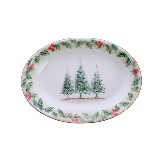 A small oval Natale hand painted ceramic platter with 3 trees in the center on a plain white background
