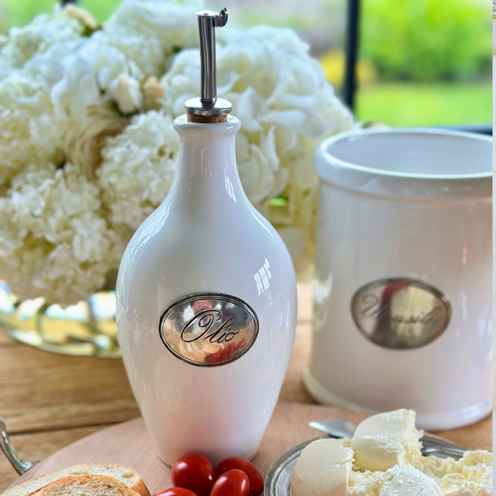 Olive Oil Bottle on a wooden table with ceramic utensil holder in background