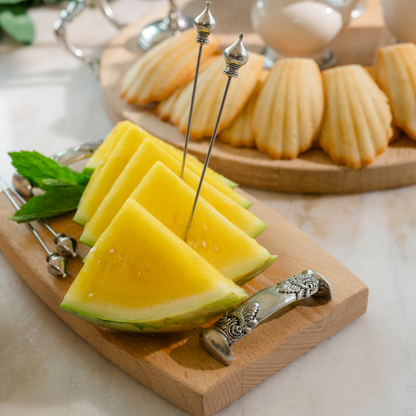 Regale Wood Bar Board on a table with yellow watermelon and Martini Crown Picks