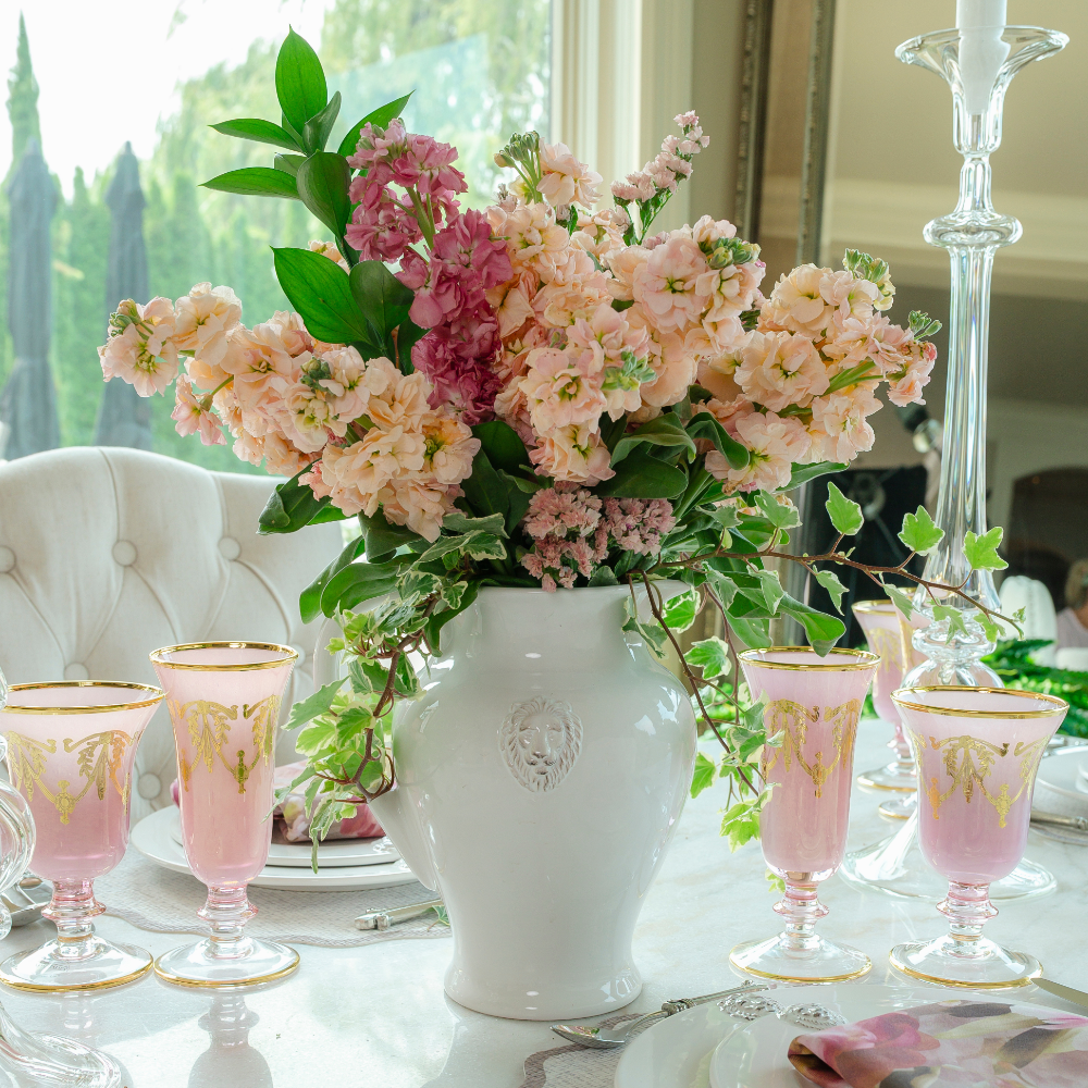  Rialto Borghese Pink with Gold Water Wine Glass and Flute on a table with Pink flowers in a Leone Pitcher