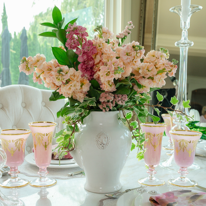  Rialto Borghese Pink with Gold Water Wine Glass and Flute on a table with Pink flowers in a Leone Pitcher