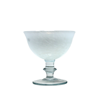 A white swirled glass compote with a marbled look and a soft pink hue, featuring a flared bowl on a stem.