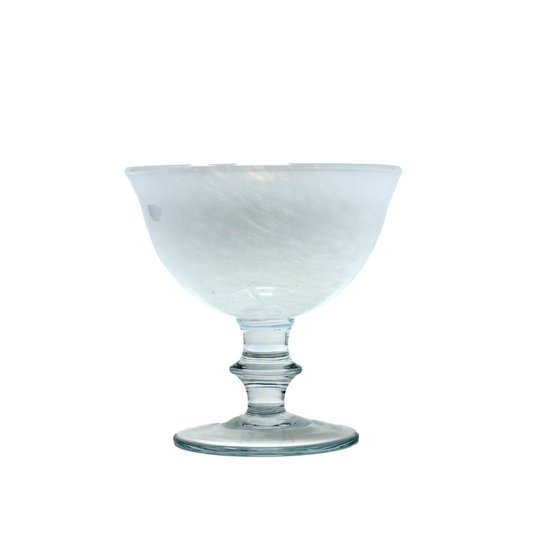 A white swirled glass compote with a marbled look and a soft pink hue, featuring a flared bowl on a stem.