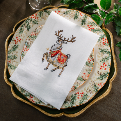 Royal Reindeer White Linen Towel folded on a Natale plate with greenery