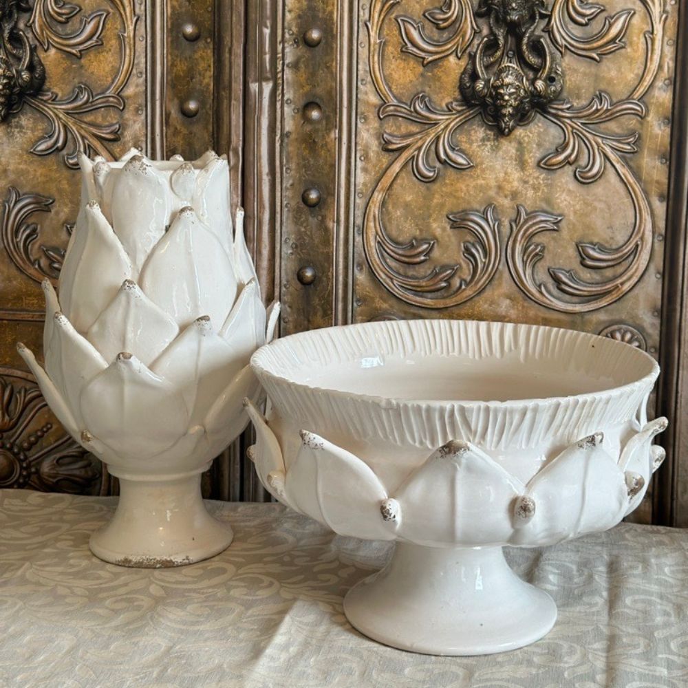 Decorative white ceramic artichoke and bowl against an ornate metallic background