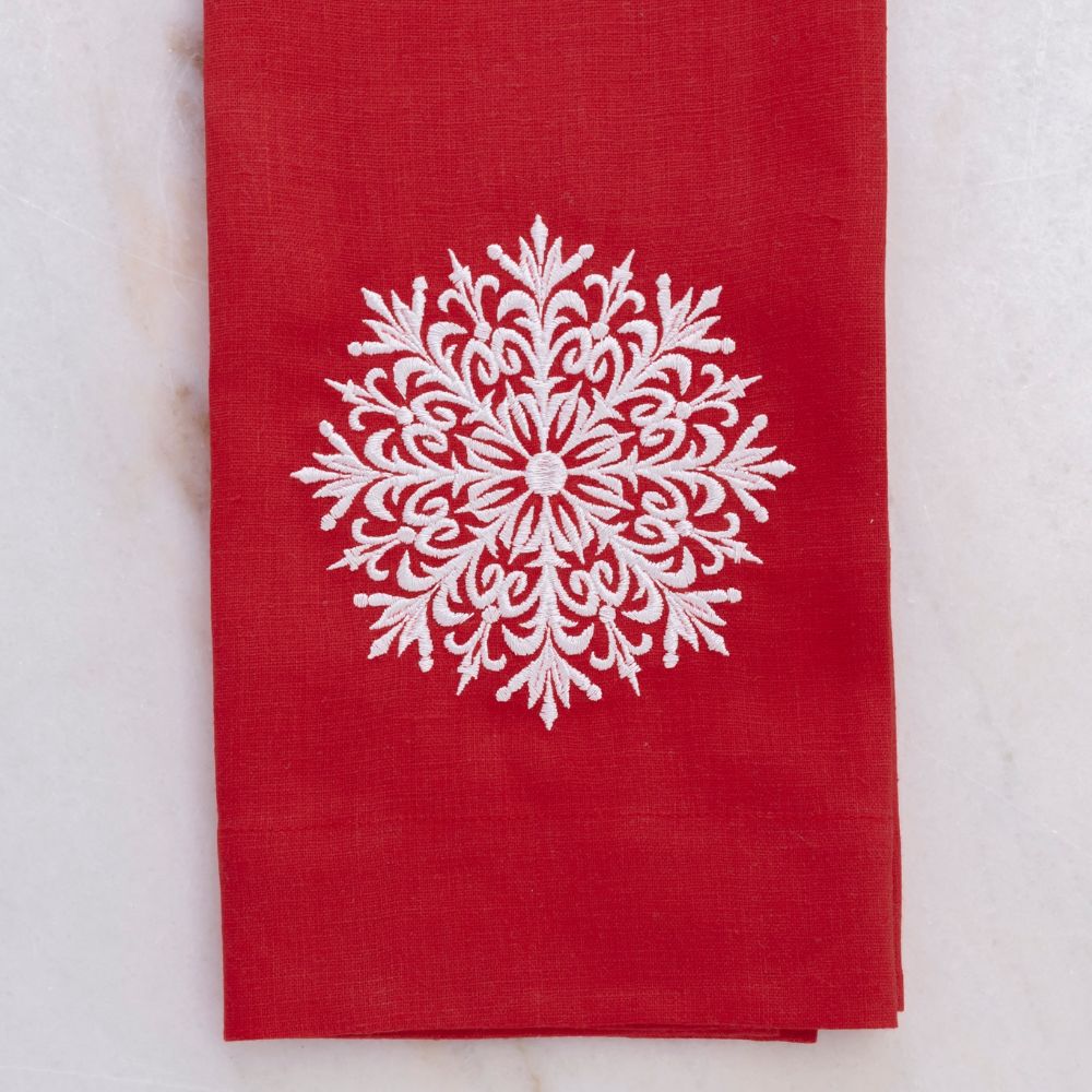 Red linen towel with a white snowflake design on a light gray background
