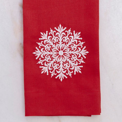 Red linen towel with a white snowflake design on a light gray background