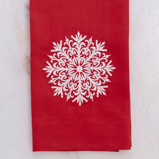 Red linen towel with a white snowflake design on a light gray background