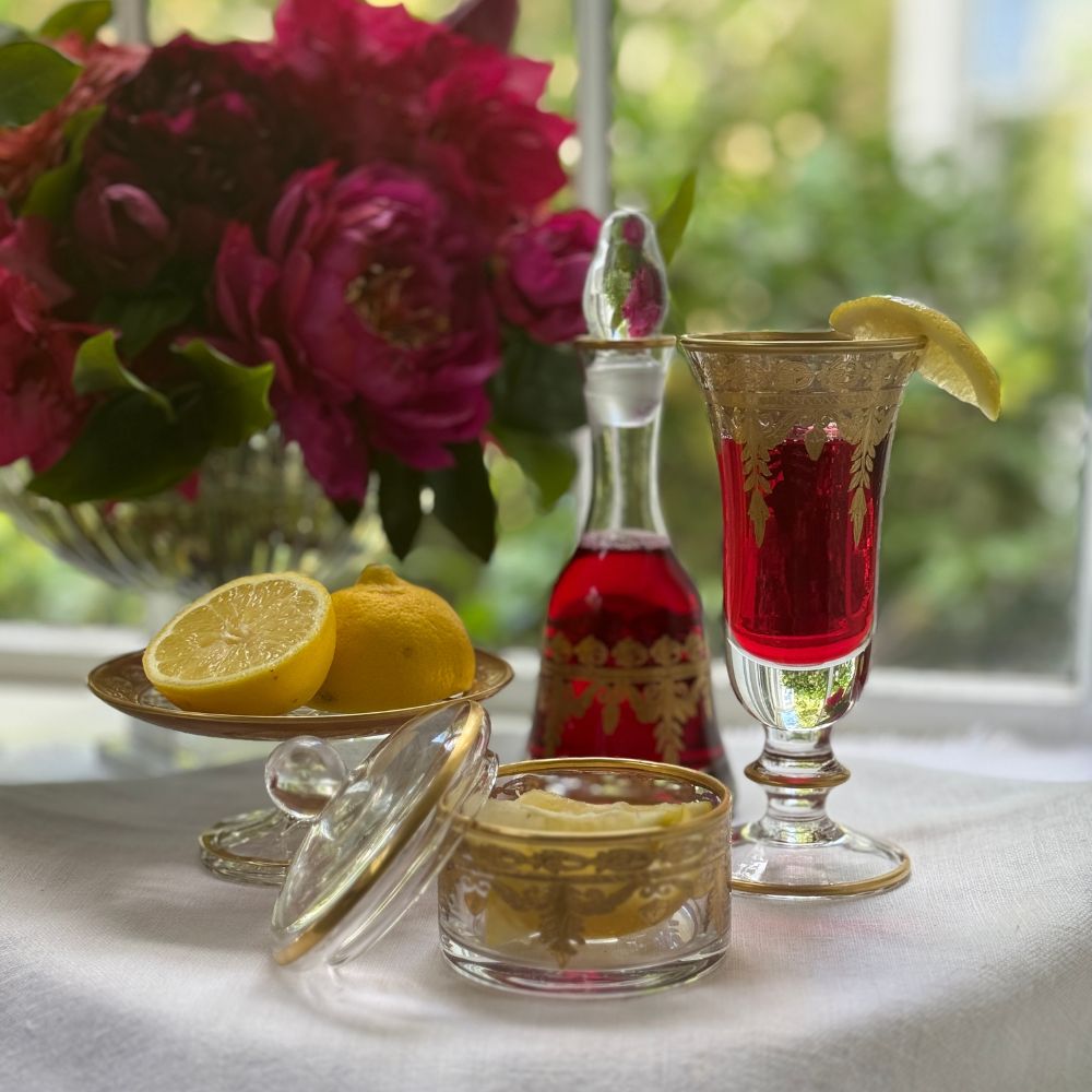 vetro gold flute glass with red beverage inside with lemons