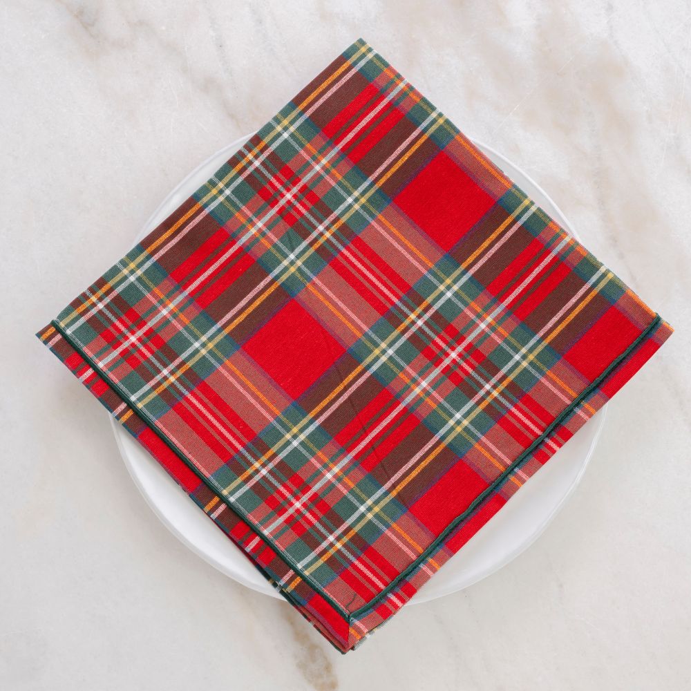 Plaid patterned napkin on a white plate with a white background